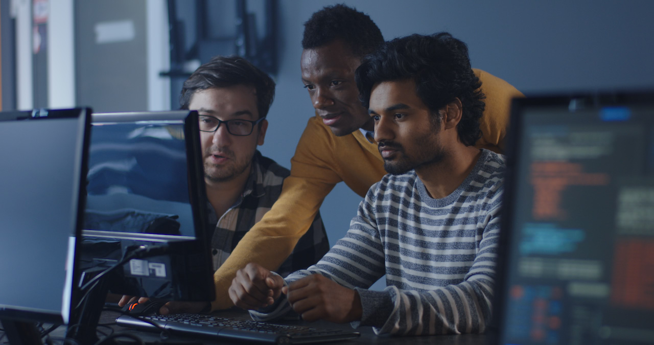 Developers coordinate a project at a shared screen