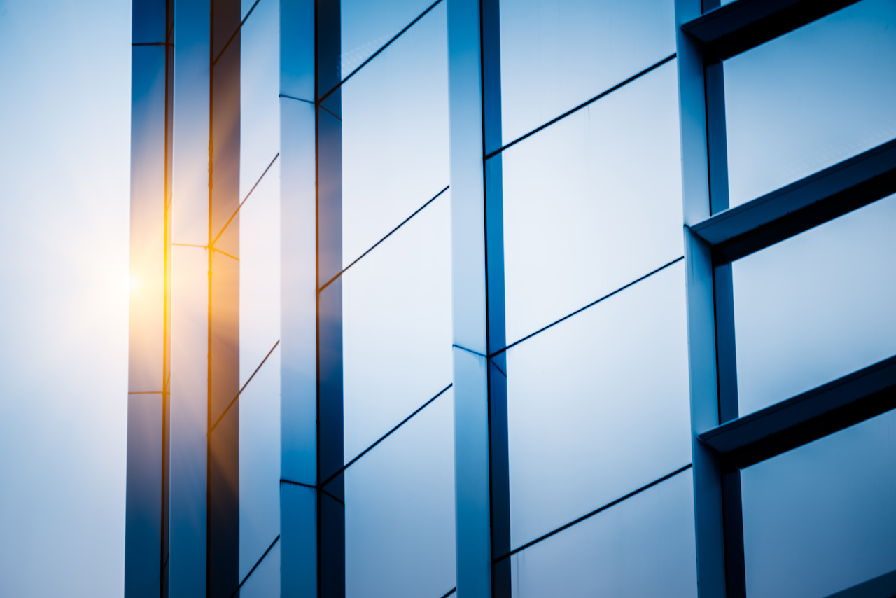 Sunlight on a blue glass and steel facade, close up