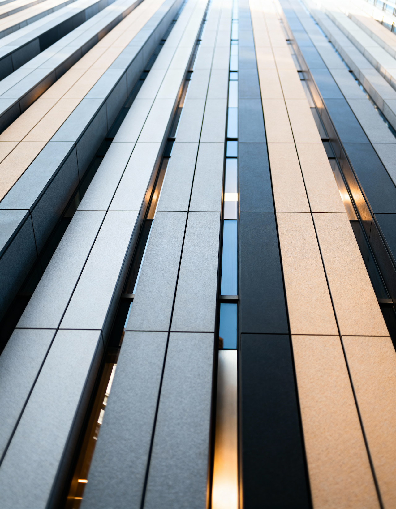 Vertical panels of a modern building facade, seen from below